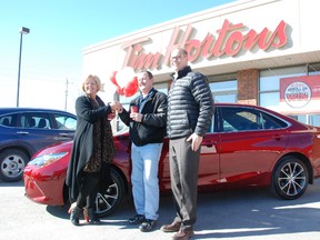David Harding, (centre) with Tim Hortons owners Mary Hanley (left) and Mark Hanley (right) received the keys to his brand new Toyota after he won in the RRRoll Up the Rim contest.
