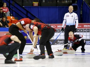 Canada's skip Pat Simmons calls a shot (R) as Scotland's skip Ewan MacDonald look on (2nd R) during the 14th draw of the World Men's Curling Championships in Halifax, Nova Scotia, April 1, 2015.    REUTERS/Mark Blinch
