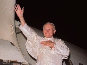 Pope John Paul II waves to the well-wishers September 1, 1988, upon his arrival to Maputo, Mozambique. (DERRICK CEYRAC/AFP)