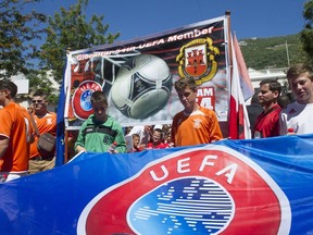 Young football players of the GFA (Gibraltar Football Association) parade with a UEFA banner as they celebrate their newly granted UEFA membership in the streets of Gibraltar on May 31, 2013. (AFP PHOTO/ MARCOS MORENO)