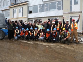 Volunteers and stakeholders celebrate the continued progress of the Neufeld Landing Habitat for Humanity project in south Edmonton.