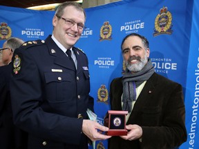 Edmonton Police Service acting chief Brian Simpson, left, and Beth Shalom Synagogue Rabbi Kliel Rose pose for a photo holding an exclusive EPS commemorative coin at EPS headquarters, 9620 – 103A Ave., on Thursday April 2, 2015 in Edmonton, AB.  TREVOR ROBB/EDMONTON SUN