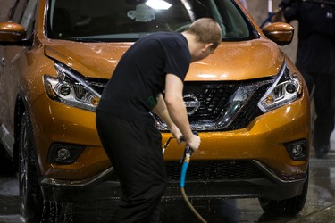 Zach Corey with Integrated Automotive Experience washes a Nissan Murano during setup for the 2015 Edmonton Motorshow at Edmonton Expo Centre in Edmonton, Alta., on Thursday, April 2, 2015. The show runs from April 9 to 12, 2015. The Precious Metal Gala is on April 8 at 6:30 p.m. Ian Kucerak/Edmonton Sun/ QMI Agency