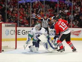 Chicago Blackhawks center Jonathan Toews (19) watches a shot hit the post behind Vancouver Canucks goalie Eddie Lack (31) during the third period at the United Center. Chicago won 3-1. Dennis Wierzbicki-USA TODAY Sports