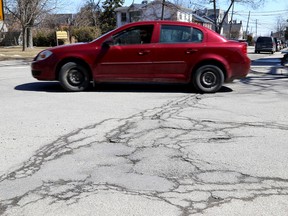 Vehicles drive past cracked asphalt at the corner of Ordnance and Clergy Streets in Kingston on Thursday April 2 2015   2015. Ian MacAlpine/The Kingston Whig-Standard/QMI Agency