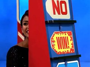Model Manuela Arbelaez attempts to hide after accidentally giving away a new car on The Price is Right. (YouTube screengrab)