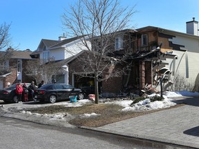 A family stands outside their burnt out Peacock Cres. house in Ottawa Friday April 3, 2015.  
Tony Caldwell/Ottawa Sun/QMI Agency
