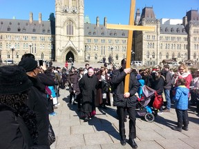 Rev. Terrence Prendergast, Archbishop of Ottawa, leads the Way of the Cross walk to observe Good Friday in Ottawa on Friday, April 3, 2015. Thousands walked from St. Patrick's Basilica to Notre Dame Cathedral to remember the walk Jesus endured before he was crucified.
(Keaton Robbins/Ottawa Sun)