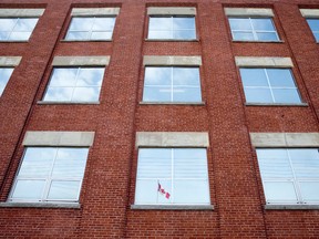 A Canadian flag is reflected in a window in the former Kellogg plant on Dundas St. in London. (CRAIG GLOVER, The London Free Press)