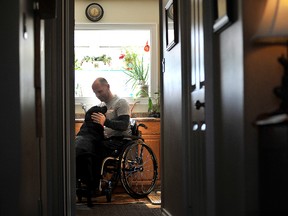 Tyler Andrews who contracted Lyme disease back in fall 2013, spends a moment with his dog Bella. The disease has left him paralyzed from the chest down. 
(Mark Wanzel/QMI Agency)