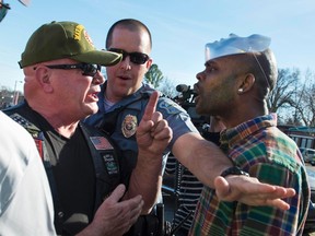 A Ferguson police officer tries to separate a supporter of Michael Brown, right, from a Ferguson police supporter, outside the Ferguson Police Department and Municipal Court in Ferguson, Mo., in this March 15, 2015 file photo. (REUTERS/Kate Munsch)