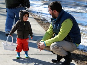 Paul Clifford with son Kaz Clifford, 2, at a neighbourhood Easter egg hunt in Skeleton Park in Kingston, Ont. on Saturday April 4, 2015. Steph Crosier/Kingston Whig-Standard/QMI Agency