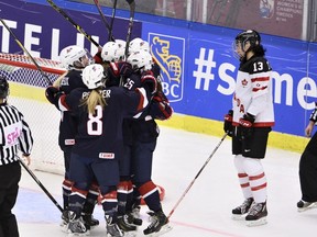 U.S. players celebrate Megan Keller's goal next to Canada's Caroline Ouellette during the 2015 IIHF Ice Hockey Women's World Championship gold medal match at Malmo Isstadion on April 4, 2015. (REUTERS/Claudio Bresciani/TT News Agenc)