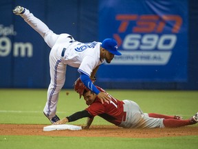 Blue Jays rookie second baseman Devon Travis goes up and over the Reds’ Kristopher Negron in Montreal yesterday. Travis is one of six rookies that made the Jays’ opening day roster. JOEL LEMAY/QMI AGENCY)