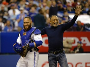 Blue Jays catcher Russell Martin is accompanied by his father Russell Martin Sr. as he leaves the game in the seventh inning against the Cincinnati Reds at the Olympic Stadium yesterday. The Jays open up the season tomorrow in New York. (USA TODAY)