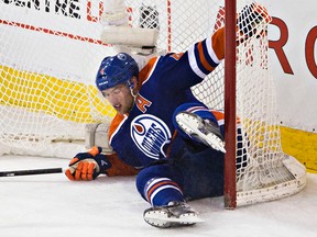 Taylor Hall tumbles into the net Saturday night (Codie McLachlan, Edmonton Sun).
