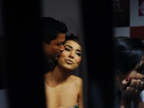 Model Ayyan Ali is kissed on her cheek by her makeup artist before she takes to the catwalk on the first day of Fashion Pakistan Week in Karachi on April 9, 2013. (REUTERS/Insiya Syed)