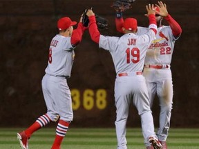 St. Louis Cardinals left fielder Peter Bourjos (left) and centre fielder Jon Jay (centre) and right fielder Jason Heyward (right) celebrate their victory following the ninth inning against the Chicago Cubs at Wrigley Field, Sunday, April 5, 2015. (Dennis Wierzbicki-USA TODAY Sports)