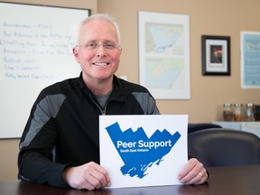 Garry Laws, CEO of the newly re-named Peer Support South East Ontario (PSSEO) organization shows off their new logo in his Front Street office in Belleville.
