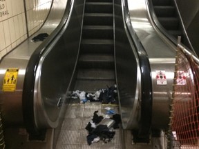 Emergency workers' gloves and torn clothing can be seen at the base of an escalator at St. Clair West station. (DAVE THOMAS/Toronto Sun)