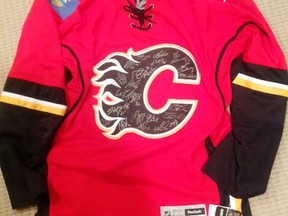This 2014-15 Calgary Flames jersey, signed by the entire team, is one of the items up for grabs in the silent auction at the third annual Guns-N-Hoses charity hockey game, set to take place at the Maitland Recreation Centre on April 11. (Contributed photo)