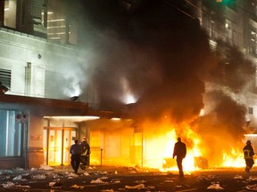Police and fire crews watch as two cars burn after a riot broke in Downtown Vancouver June 15, 2011. (FILE PHOTO)