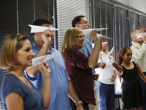 Participants prepare to launch paper airplanes during Captain Ron Nielsen's "Fearless Flying" class at Sky Harbor International Airport in Phoenix, Arizona April 4, 2015. REUTERS/Nancy Wiechec