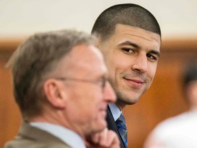 Former New England Patriots player Aaron Hernandez (R) smiles at his attorney Charles Rankin during his murder trial at Bristol County Superior Court in Fall River, Massachusetts March 31, 2015. (REUTERS/Aram Boghosian/Pool)