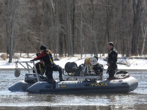 A Quebec provincial police dive team searches the Ottawa River behind the Abitibi Bowater paper mill in Gatineau, Que., on April 7, 2015. Two teenage boys fell into the water in the area the night of April 6 but one remains missing.  Andrew Meade/ Ottawa Sun