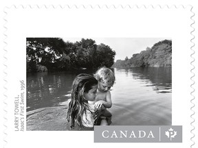 Larry Towell's photograph, taken in 1996, of his daughter Naomi immersing her little brother Isaac in the Sydenham River, from his book 'The World From My Front Porch' has been included in a series of seven new stamps being released by Canada Post on Wednesday, April 8, 2015 to celebrate Canadian photography. (Handout/Chatham Daily News/QMI Agency)