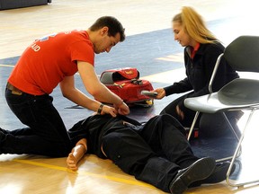 Brandon Ber and Olivia Giovannetti, representatives from Queen’s First Aid, show how the PulsePoint app works with a CPR and automated external defibrillator demonstration on Tuesday at the Queen’s Athletics and Recreation Centre. (Alisa Howlett/The Whig-Standard)