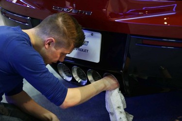 A worker cleans the exhaust pipes of Chevrolet Corvette at the 2015 Edmonton Motorshow at the Edmonton Expo Centre in Edmonton, Alberta on Tuesday, April 7, 2015. Perry Mah/Edmonton Sun/QMI Agency