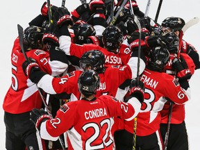 Ottawa Senators players mob teammate Mark Stone after he scored the overtime game winning goal against the  Pittsburgh Penguins during NHL hockey action at the Canadian Tire Centre in Ottawa, Ontario on April 7, 2015. Errol McGihon/Ottawa Sun/QMI Agency