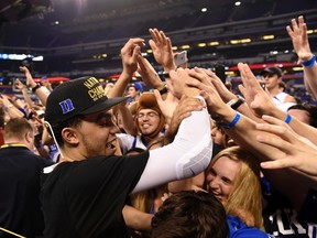 Duke's Tyus Jones celebrates with fans after winning the NCAA tournament on Monday. (USA TODAY SPORTS)