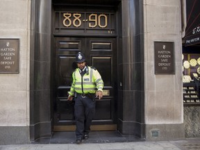 A police officer leaves a safe deposit building on Hatton Garden in central London April 7, 2015. Burglars are believed to have broken into the Hatton Garden Safe Deposit company over the Easter weekend, local media reported.  REUTERS/Neil Hall