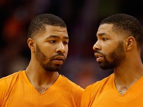 Markieff Morris (left) and Marcus Morris of the Phoenix Suns talk during an NBA game against the Sacramento Kings at US Airways Center November 7, 2014 in Phoenix. (Christian Petersen/Getty Images/AFP)