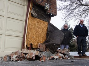 Bob Kagarias (left) and his son Elias Kagarias (right) inspect the damage that was done to their home after a car ran into it. The incident happened Tuesday at about 8:15 on the corner of Lorry Greenberg Dr. and Bramblegrove Cr.  Joel Watson/Ottawa Sun/QMI Agency
