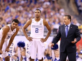 Andrew Harrison #5, Aaron Harrison #2 and head coach John Calipari of the Kentucky Wildcats look on in the first half against the Wisconsin Badgers during the NCAA Men's Final Four Semifinal at Lucas Oil Stadium on April 4, 2015 in Indianapolis, Indiana. (Streeter Lecka/Getty Images/AFP)