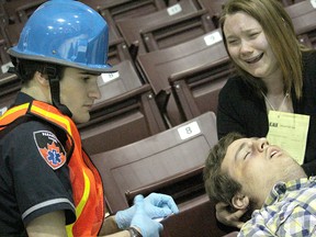 Paramedic student Matt Burdeu tends to student-actors Zach Roos and Brittaney Conely during a training scenario for Lambton College students at the RBC Centre Wednesday. The mock-mass-casualty scenario was designed to test the college's paramedic, fire, police and nursing students. (TYLER KULA/ THE OBSERVER/ QMI AGENCY)
