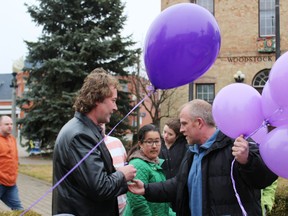 Rodney Stafford, father of Victoria Stafford, hands a bracelet and balloon to Woodstock Mayor Trevor Birtch. (Megan Stacey/Sentinel-Review)