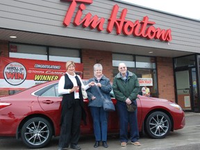 JESSICA LAWS/ FOR THE INTELLIGENCER
Trish Martin (left) handed over the keys of a 2015 Toyota Camry XSE to the second Roll Up the Rim to Win winner Marsha Moodie (centre) and her husband David Moodie on Thursday.