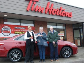 Trish Martin (left) handed over the keys of a 2015 Toyota Camry XSE to the second Roll Up the Rim to Win winner Marsha Moodie (centre) and her husband David Moodie on Thursday.
JESSICA LAWS/ Special to QMI Agency