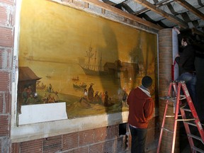 Queen's University art conservation students carefully peel back a very old painting Thursday that was found during a construction project on Bath Road. (Ian MacAlpine/The Whig-Standard)