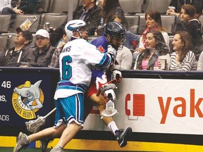 Toronto Rock’s Damon Edwards gets put into the boards by Rochester’s Dylan Evans last week. (MICHAEL PEAKE/Toronto Sun)