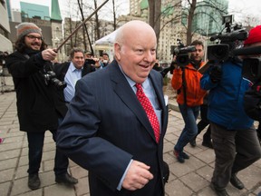 Former Senator Mike Duffy runs with journalists covering his trial outside of the Elgin Street courthouse on on Thursday April 9, 2015.
Errol McGihon/Ottawa Sun/QMI Agency