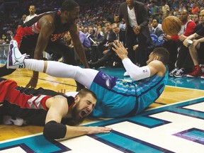Raptors’ Jonas Valanciunas is in obvious discomfort after Charlotte Hornets forward Jeff Taylor fell on his arm Wednesday. (USA TODAY SPORTS)
