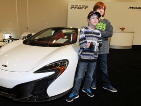 Nine-year-olds Jackson Caskey (left) and Graydie Snowden pose for photos with a McLaren 650s Spyder at the Edmonton Motorshow at the Expo Centre on Thursday. (Perry Mah/Edmonton Sun)