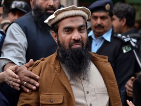 Pakistani security personnel escort Zaki-ur-Rehman Lakhvi, centre, alleged mastermind of the 2008 Mumbai attacks, as he leaves the court after a hearing in Islamabad in this Jan. 1, 2015 file photo. (AFP PHOTO/Aamir Qureshi/FILES)
