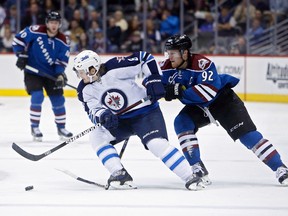 Colorado Avalanche left wing Gabriel Landeskog breaks his stick attempting to steal the puck away from Winnipeg Jets defenseman Jacob Trouba (8) during the second period of Thursday night's game in Denver. (Chris Humphreys-USA TODAY Sports)