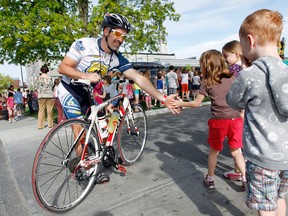 Intelligencer file photo by Jerome Lessard
Central Hastings OPP officer Sgt. James Locke, high-fives students at St. Michael Catholic School in Belleville after he led the 2013 Pedal for Hope parade, composed of  Belleville police officers and other local OPP officers. The tour, now in its fourth year, is making its way to area schools beginning later this month.